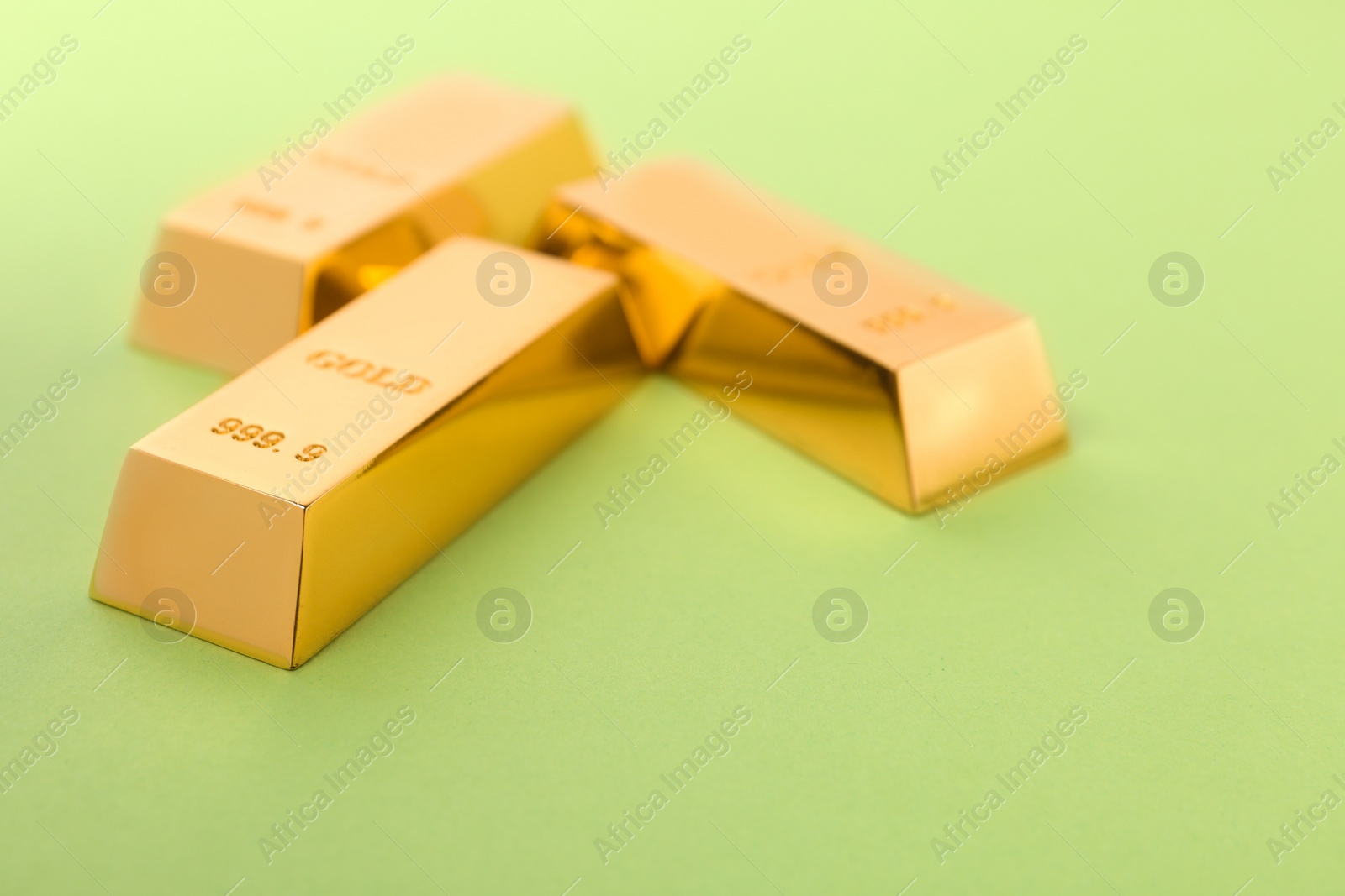 Photo of Precious shiny gold bars on color background