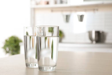 Photo of Glasses of fresh water on table indoors. Space for text