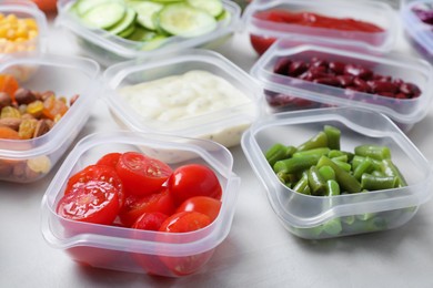 Photo of Set of containers with fresh food on white table