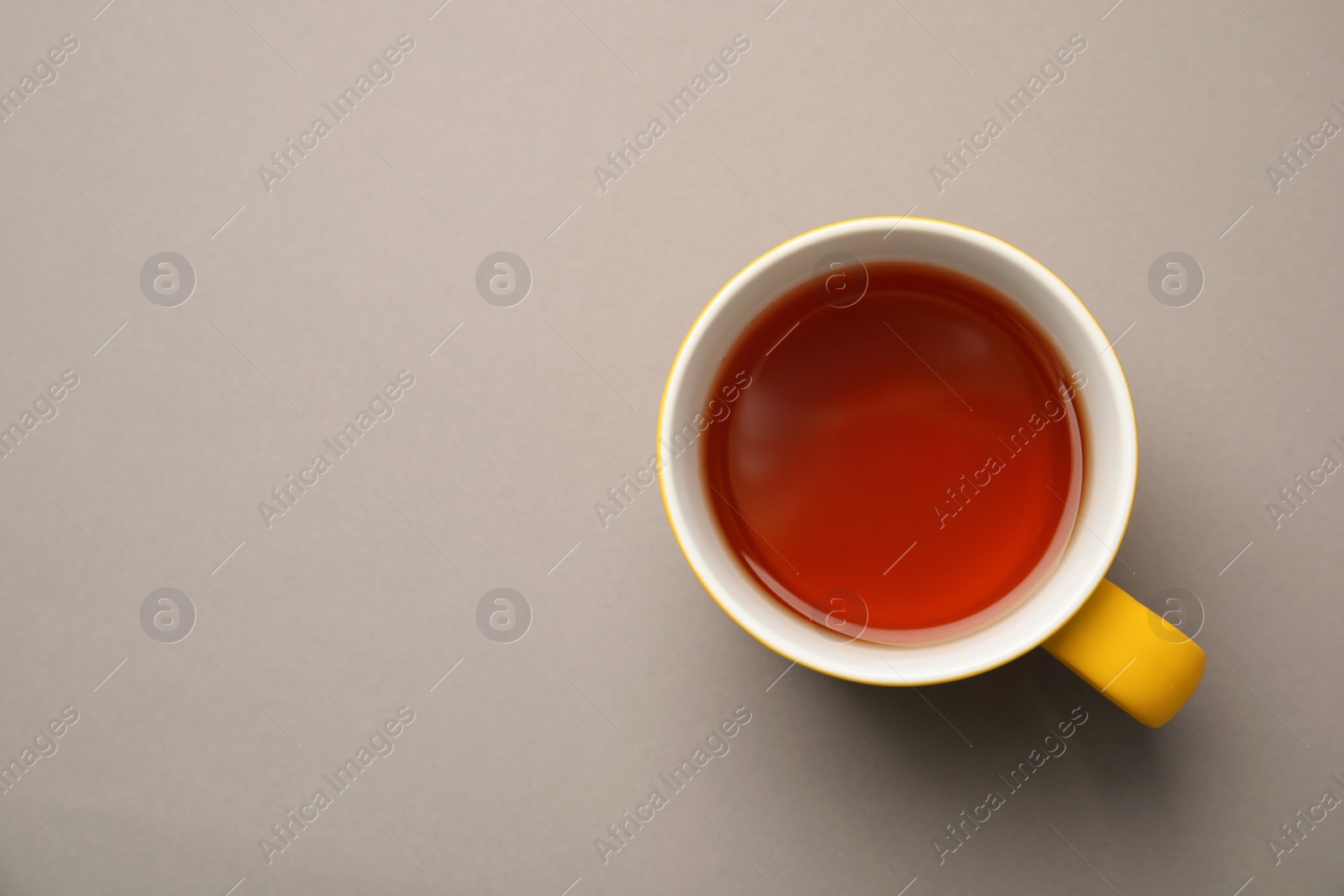 Photo of Cup of black tea on color background, top view