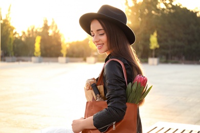 Photo of Young woman with leather shopper bag sitting on bench