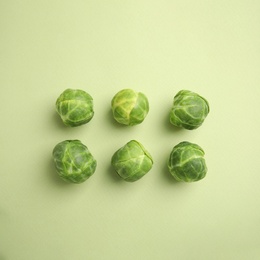 Photo of Fresh Brussels sprouts on green background, flat lay