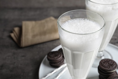 Glass of milk with chocolate cookies on table, closeup. Space for text