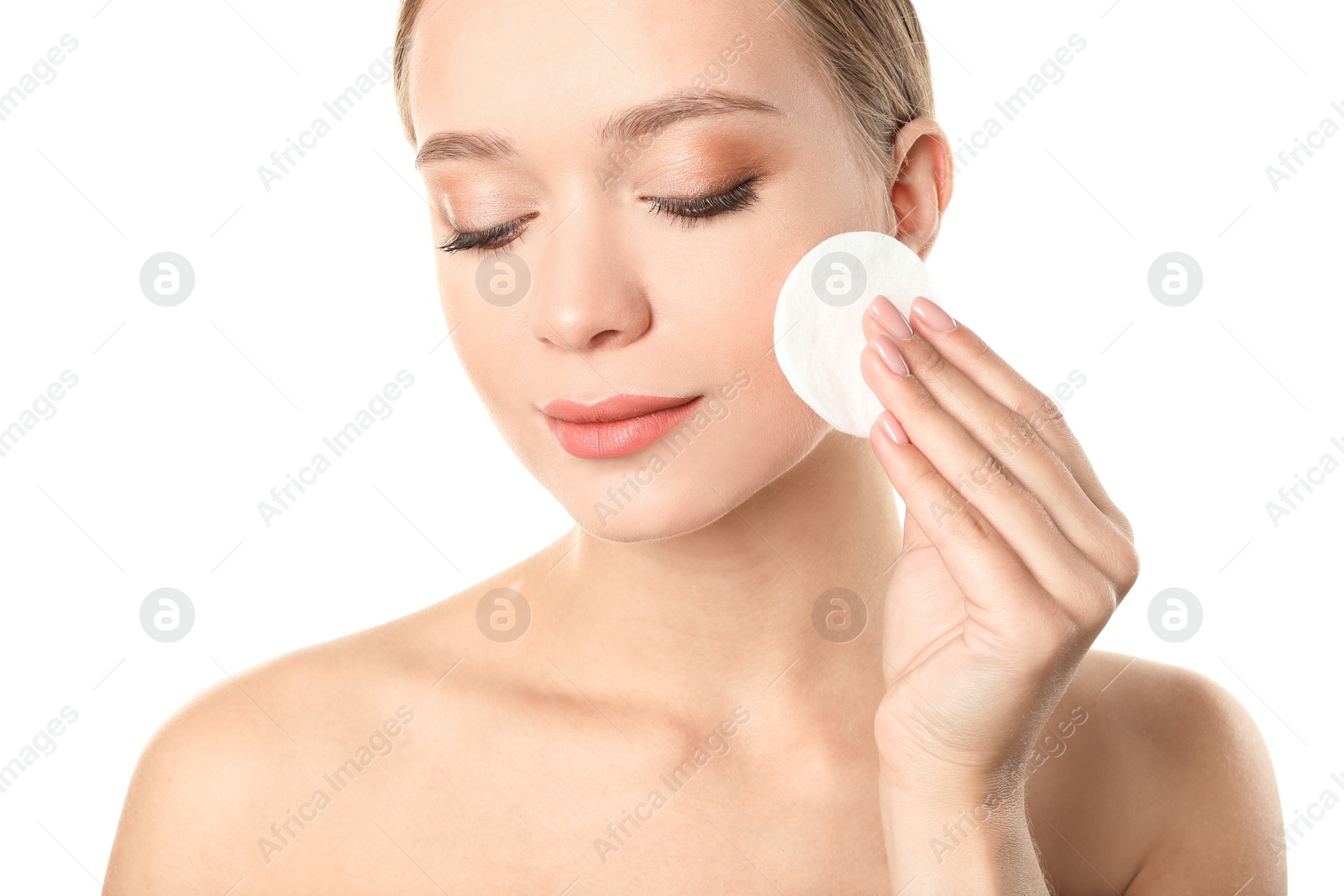 Photo of Portrait of beautiful young woman removing makeup with cotton pad on white background