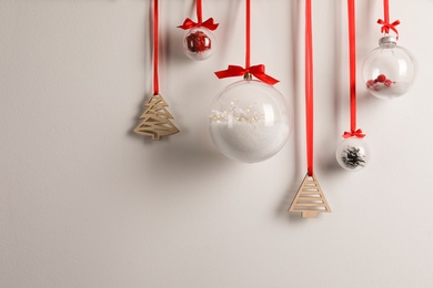 Decorative snow globes hanging on grey background