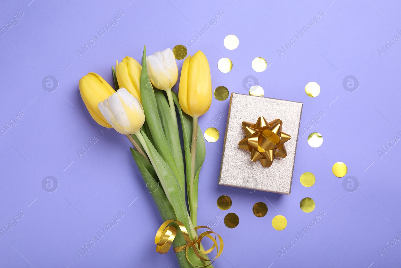 Photo of Bouquet of tulips, confetti and gift box on light purple background, flat lay