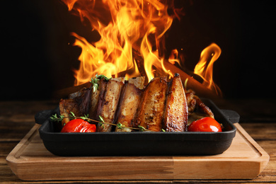 Delicious roasted ribs and flame on table