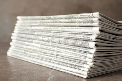 Photo of Stack of newspapers on marble table, closeup. Journalist's work