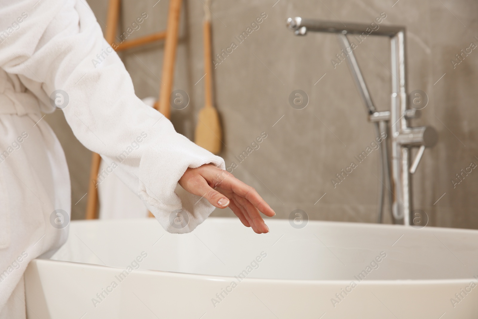 Photo of Woman sitting on edge of tub in bathroom, closeup