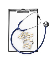 Clipboard, pills and stethoscope on white background, top view