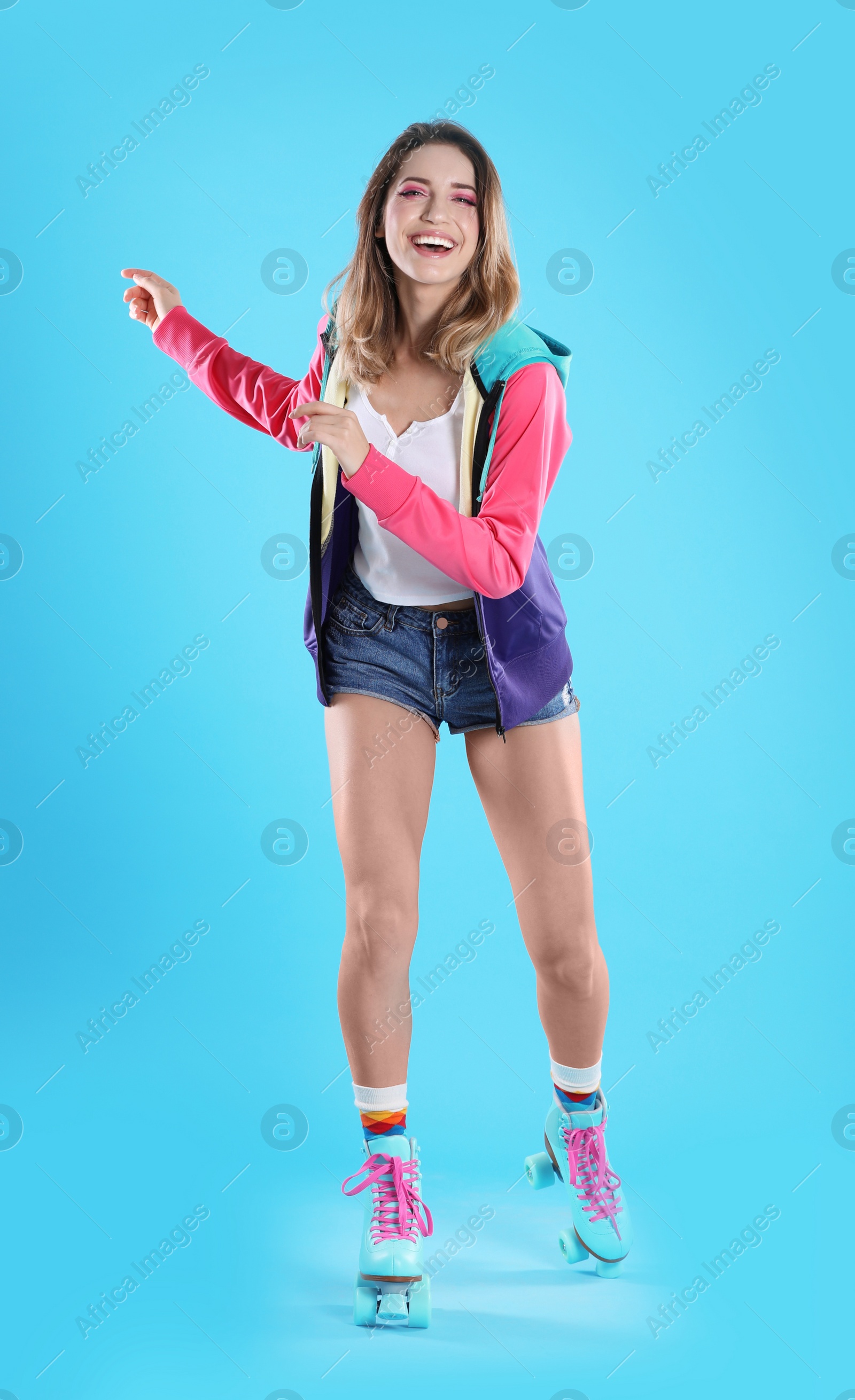 Photo of Young woman with retro roller skates on color background