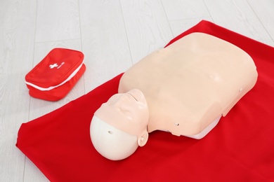 Photo of First aid mannequin and bag on floor indoors