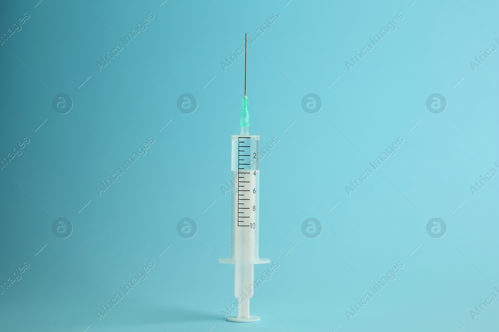 Photo of Medical syringe with liquid on light blue background