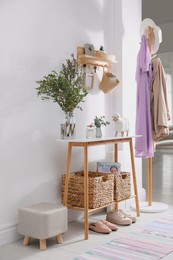 Modern hallway interior with table, clothes rack and key holder