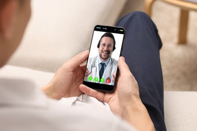 Online medical consultation. Man having video chat with doctor via smartphone at home, closeup