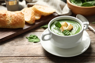 Fresh vegetable detox soup made of spinach with croutons in dish served on table. Space for text