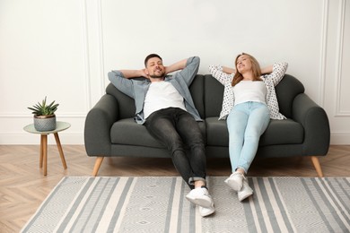 Photo of Couple relaxing on sofa in living room