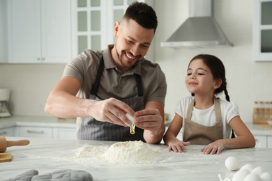 Photo of Father and daughter cooking together in kitchen