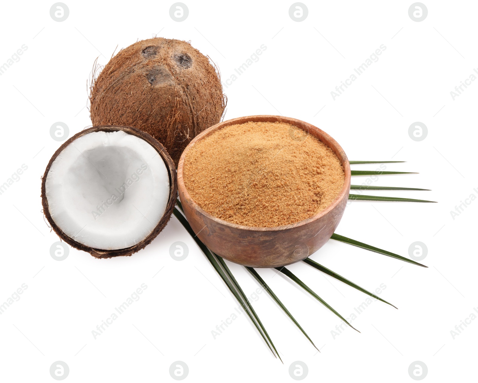 Photo of Coconut sugar in bowl, fruits and palm leaf isolated on white