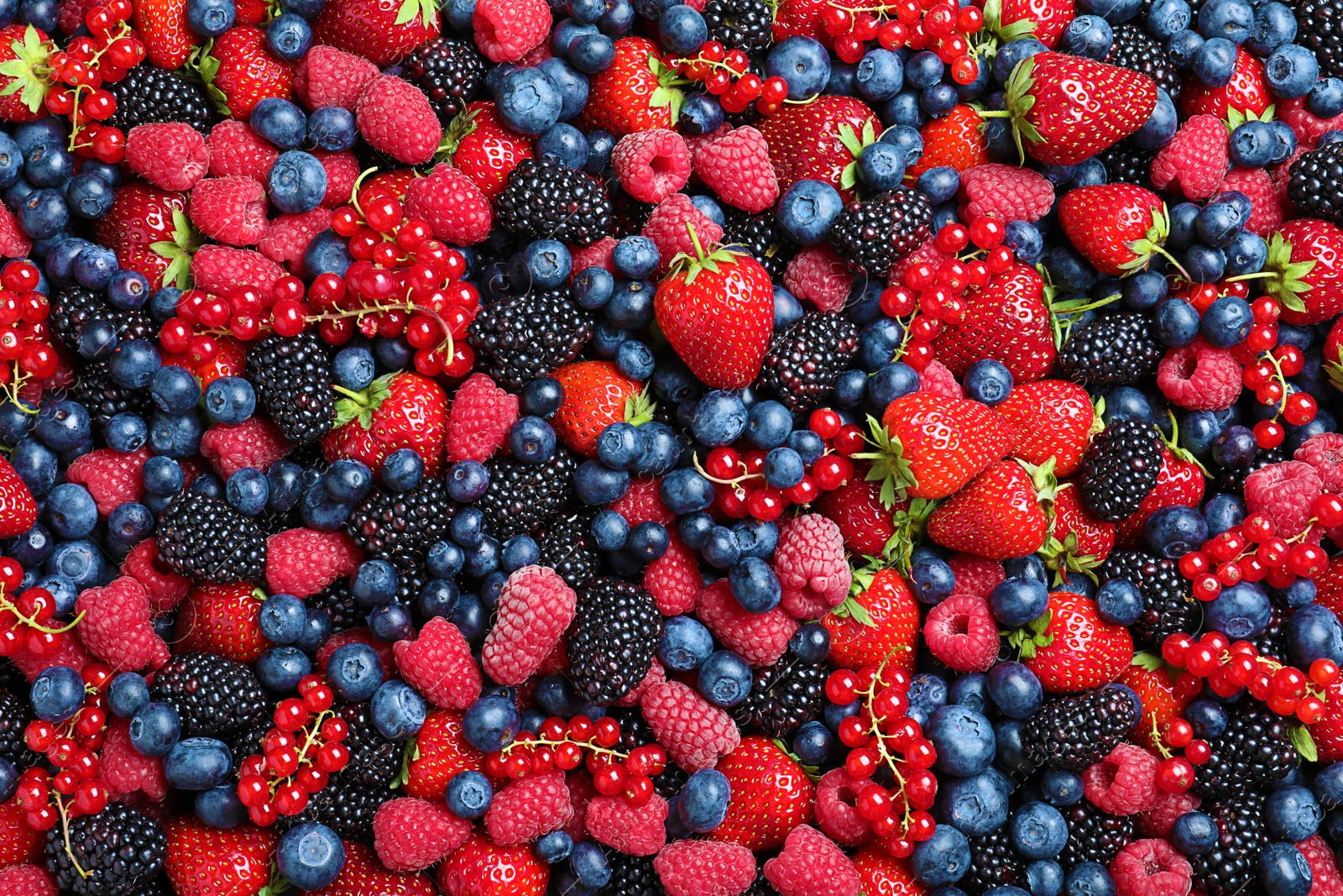 Photo of Mix of different ripe tasty berries as background, top view