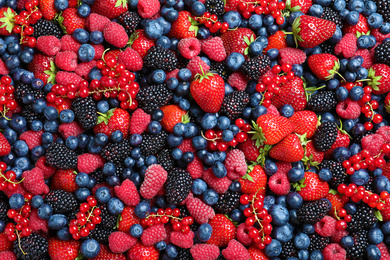 Photo of Mix of different ripe tasty berries as background, top view