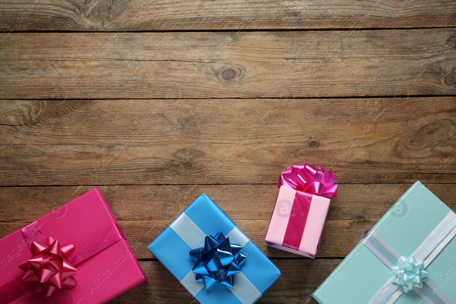 Photo of Many colorful gift boxes on wooden table, flat lay. Space for text