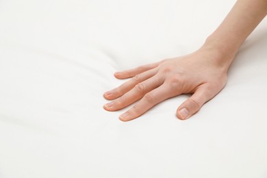 Photo of Woman touching orthopedic mattress, closeup. Space for text