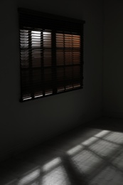 Photo of Window with horizontal blinds in dark room. Space for text