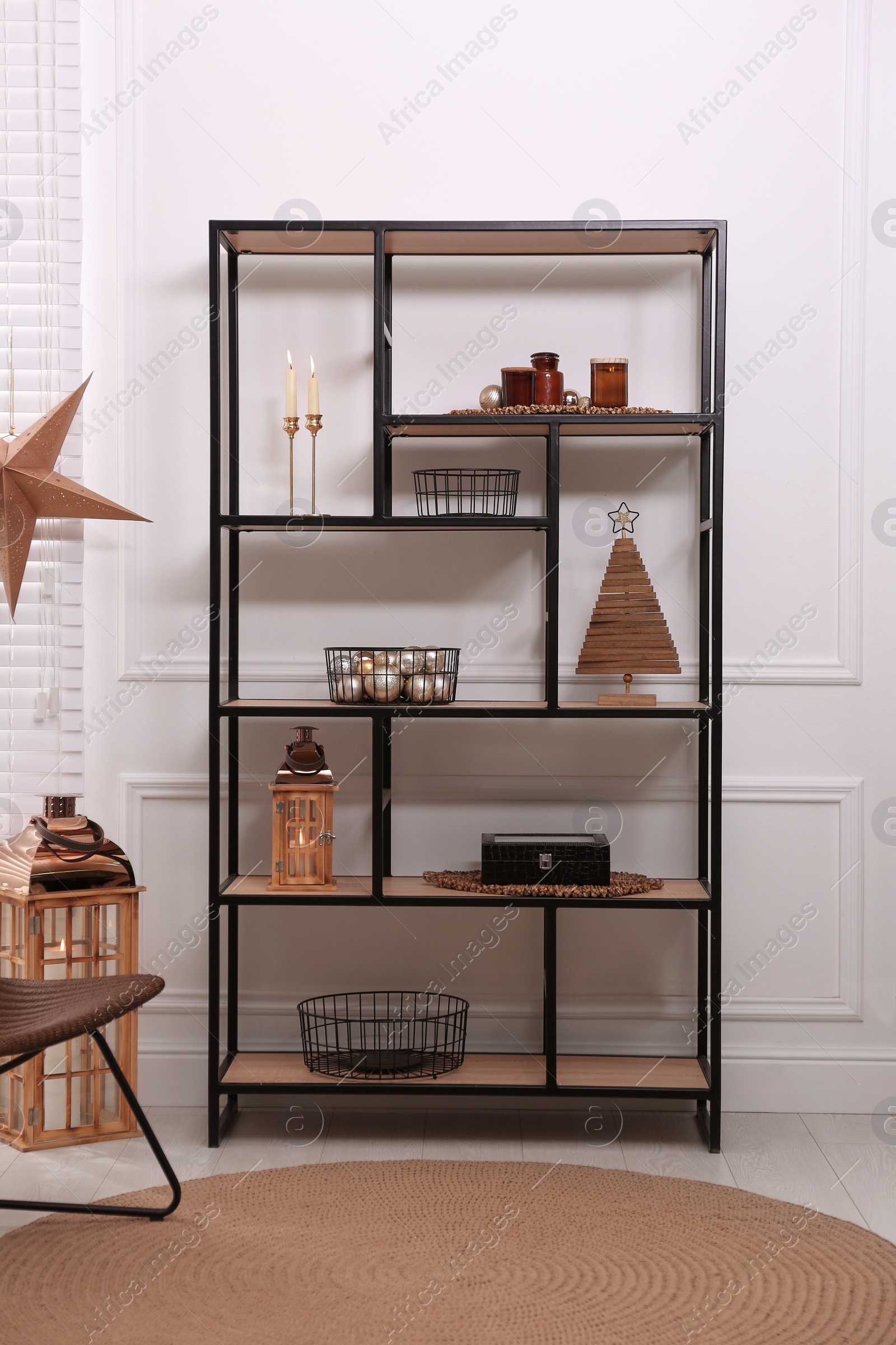 Photo of Stylish shelving unit with different decor near white wall indoors. Interior design