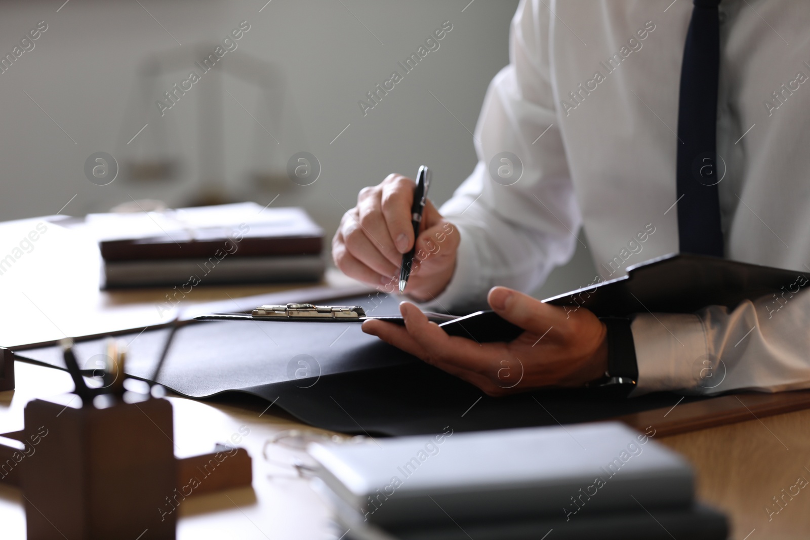 Photo of Male lawyer working at table in office, closeup