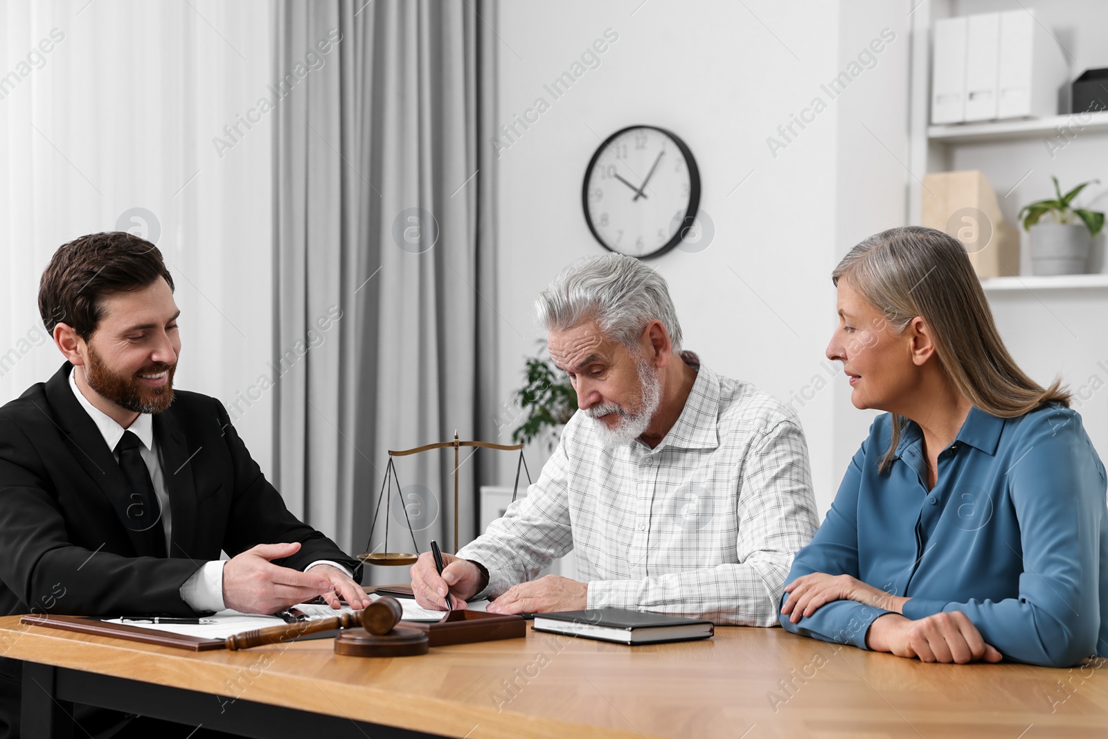 Photo of Senior couple having meeting with lawyer in office