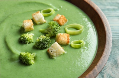 Photo of Fresh vegetable detox soup made of broccoli with croutons in dish, closeup