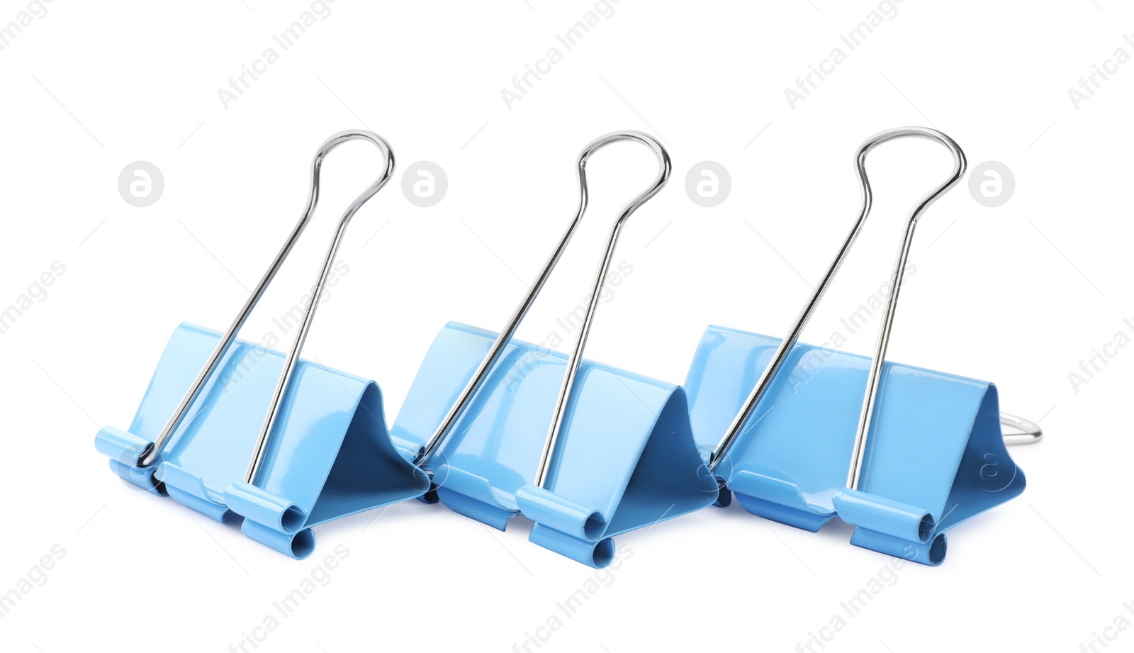 Photo of Light blue binder clips on white background. Stationery