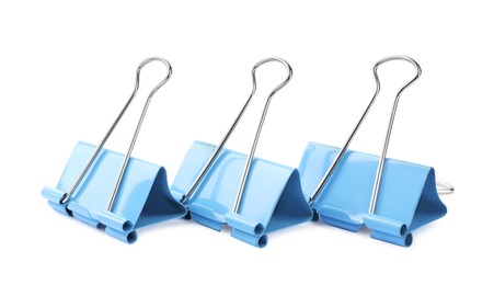 Photo of Light blue binder clips on white background. Stationery