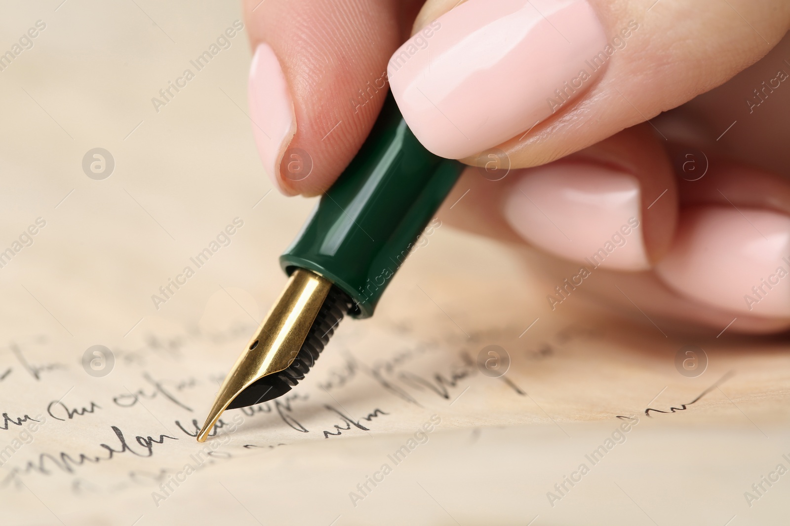 Photo of Woman writing letter with fountain pen, closeup