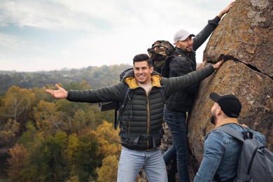 Photo of Group of hikers with backpacks climbing up mountains