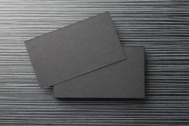 Blank black business cards on wooden table, top view. Mockup for design