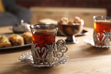 Glass of traditional Turkish tea in vintage holder on wooden table. Space for text