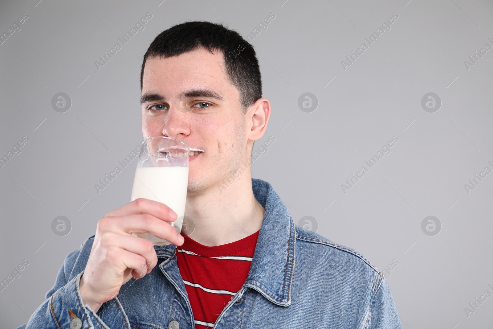 Photo of Milk mustache left after dairy product. Man drinking milk on gray background, space for text