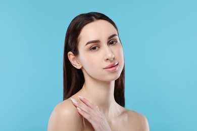 Portrait of beautiful young woman on light blue background