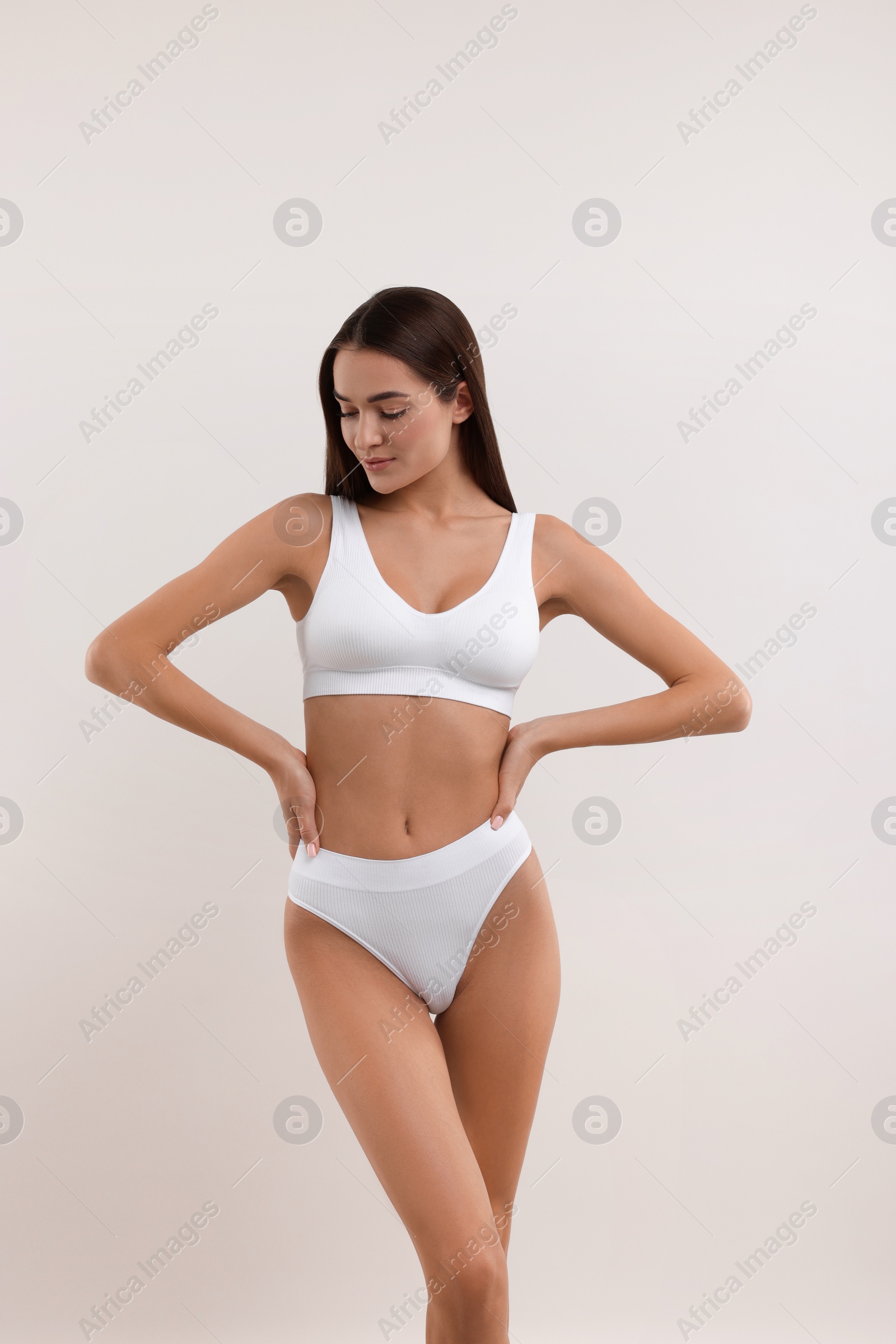 Photo of Young woman in stylish bikini on white background