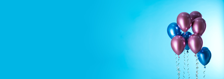 Image of Bright balloons on light blue background, space for text. Banner design 