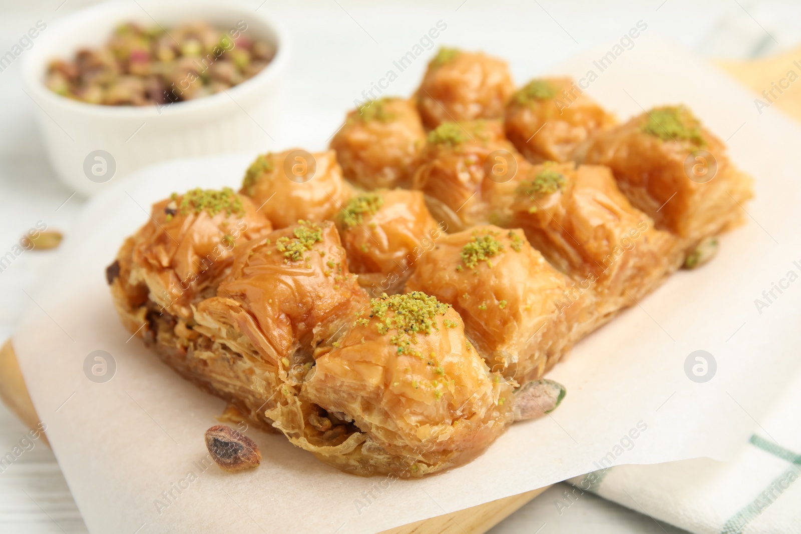 Photo of Delicious sweet baklava with pistachios on board, closeup