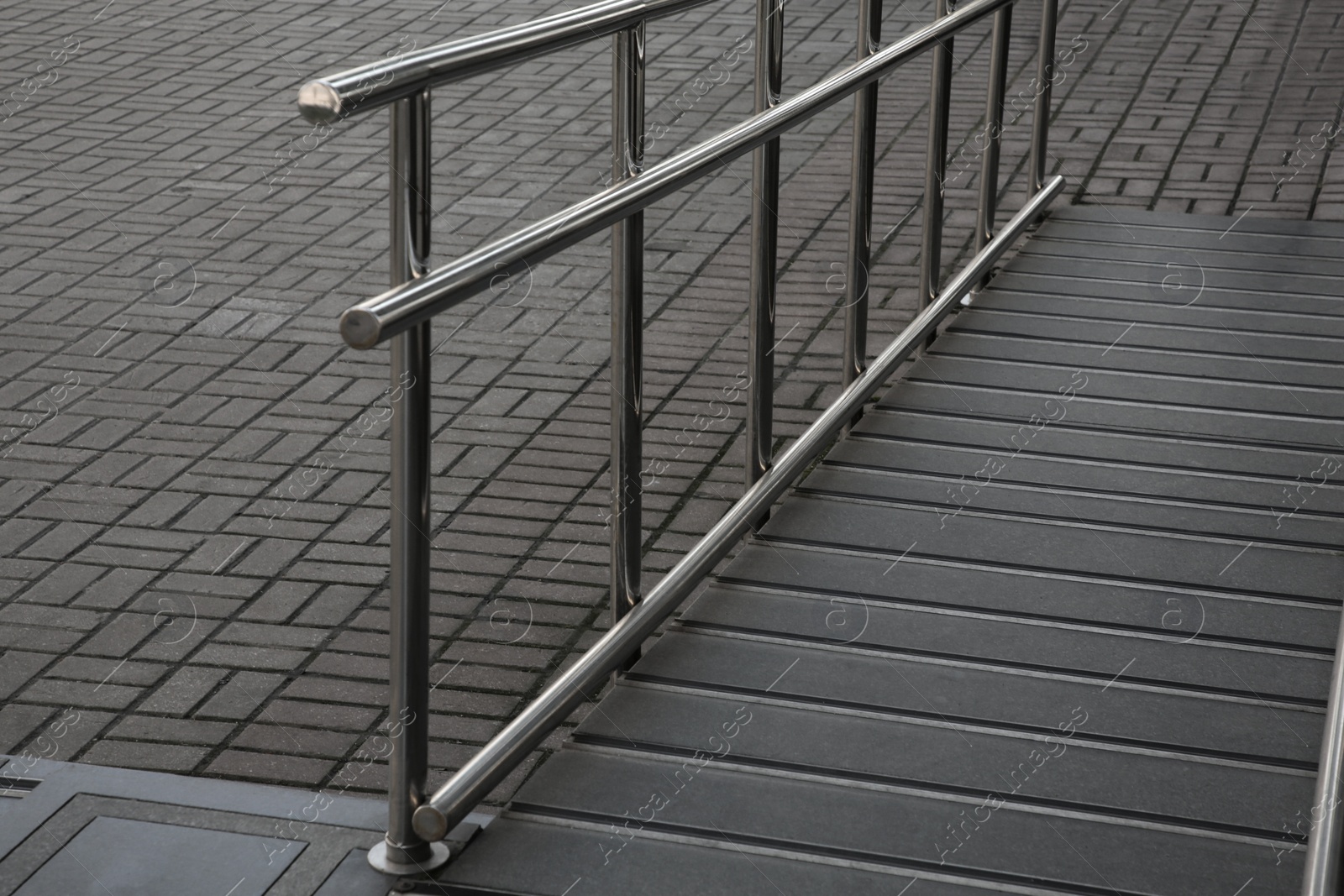 Photo of Ramp with metal railing near building outdoors