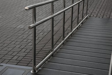 Ramp with metal railing near building outdoors