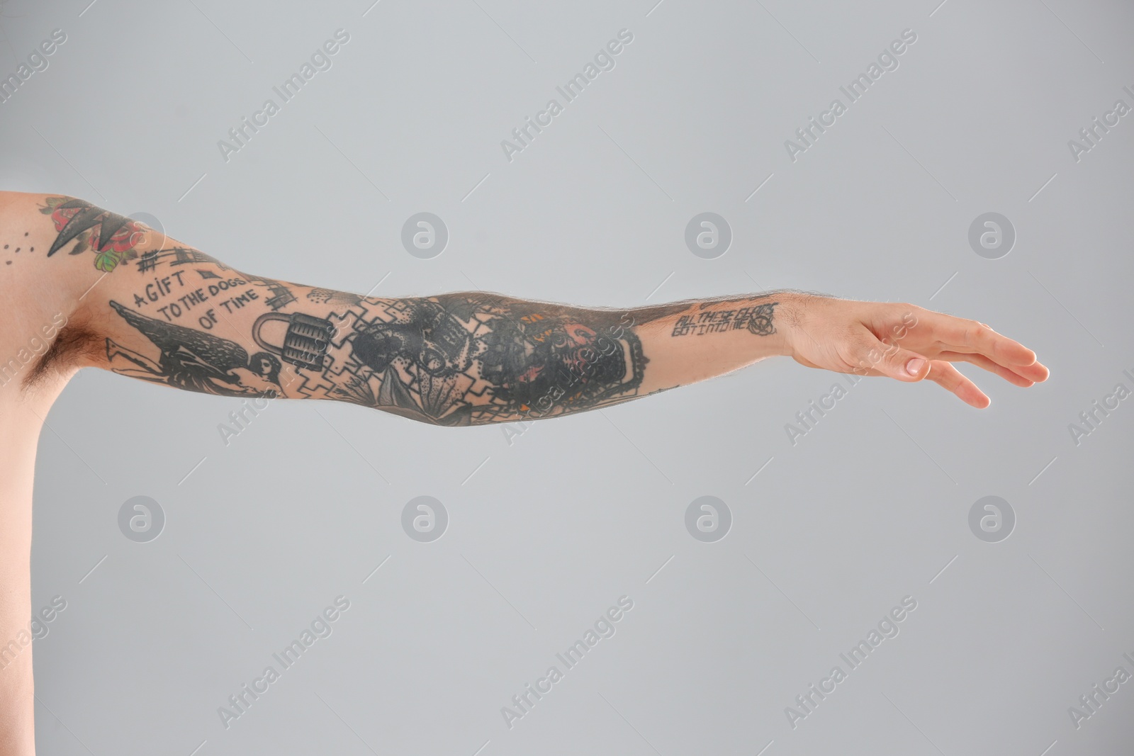 Photo of Man's arm with stylish tattoos on grey background