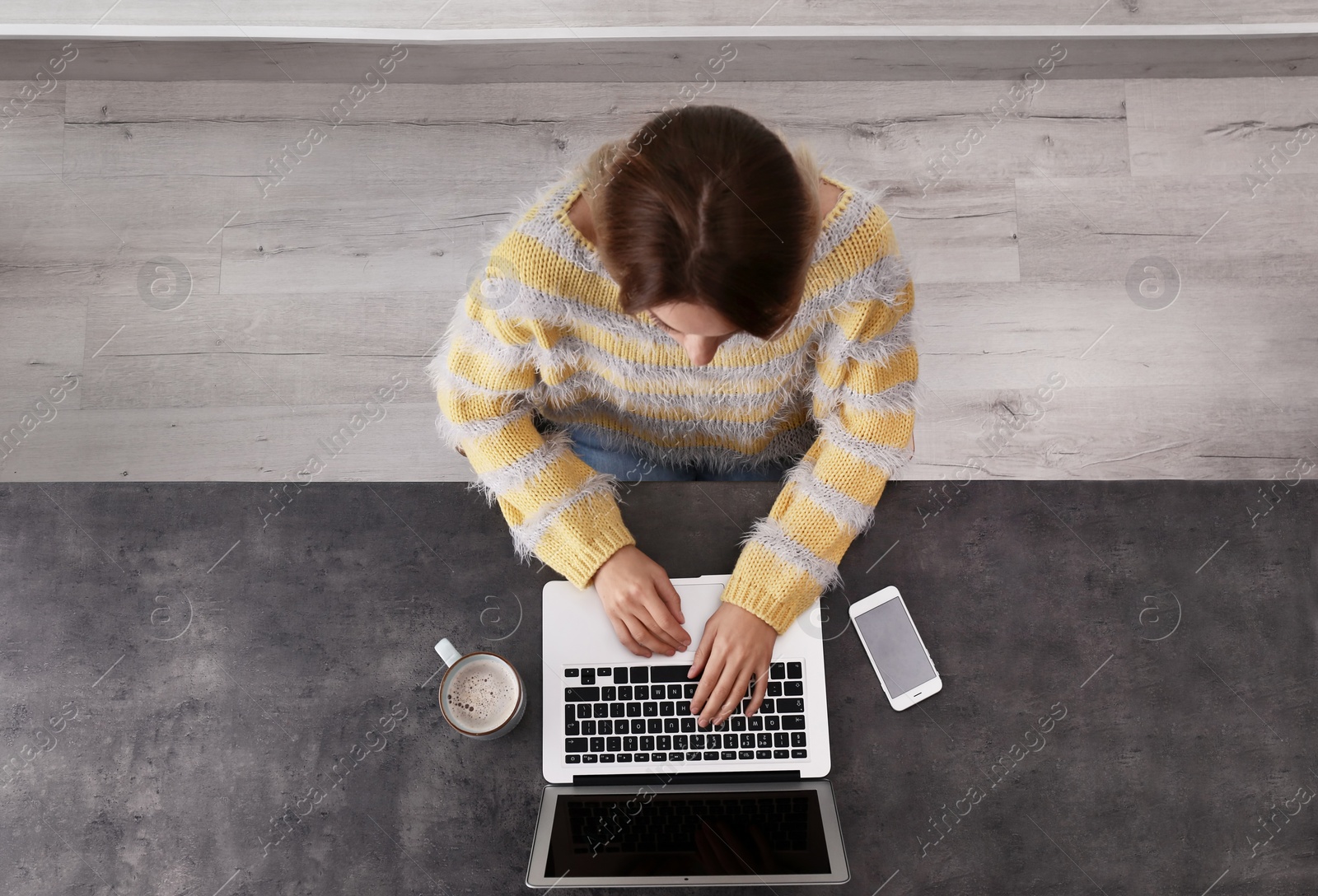 Photo of Woman working with laptop at table indoors, top view