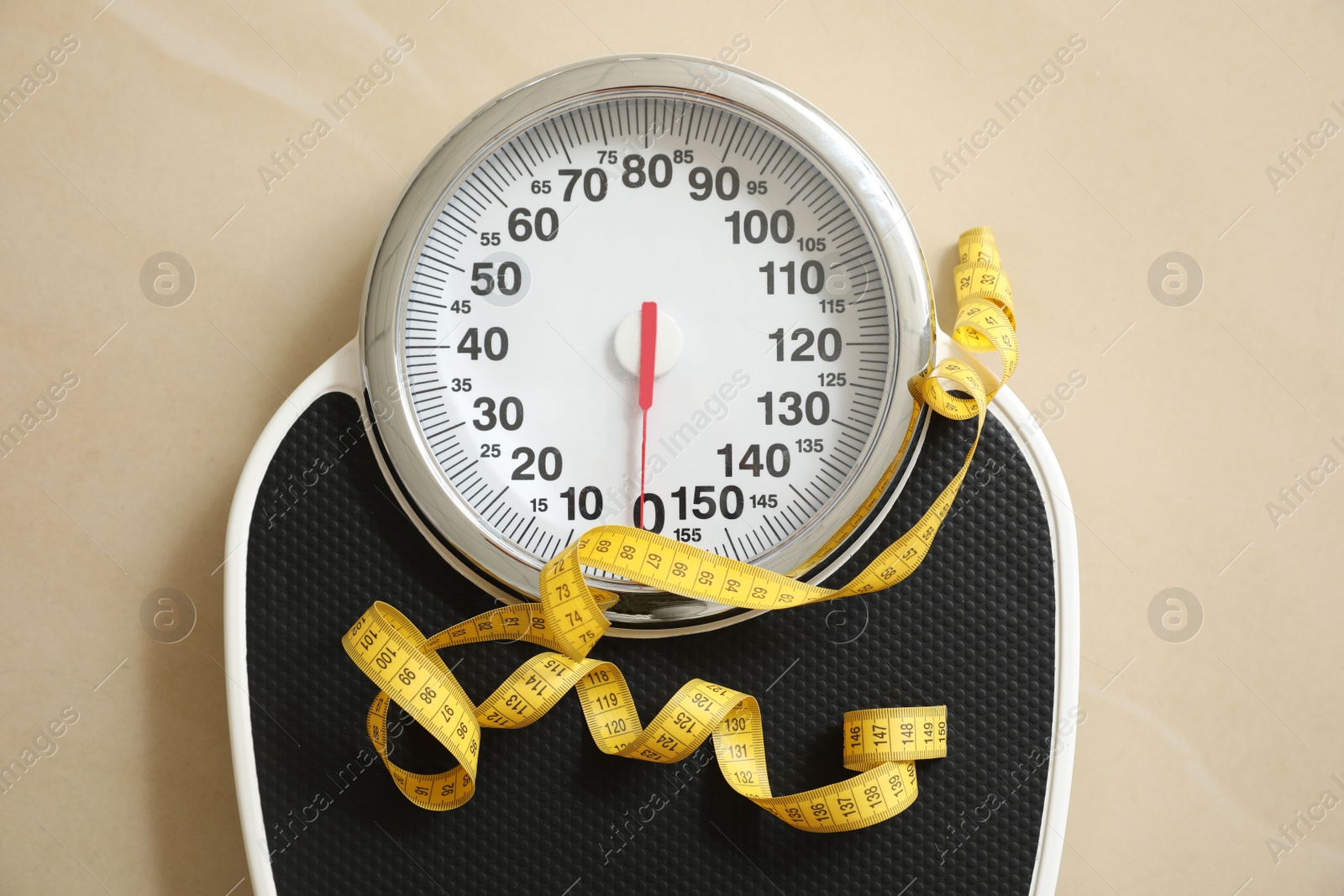 Photo of Scales and measuring tape on floor, top view. Overweight problem