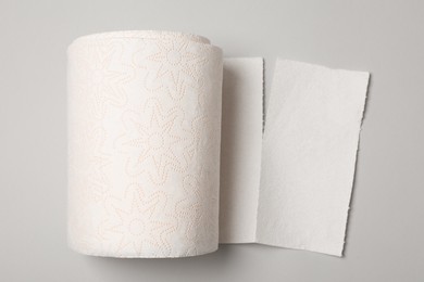 Photo of Roll of white paper towels on grey background, top view