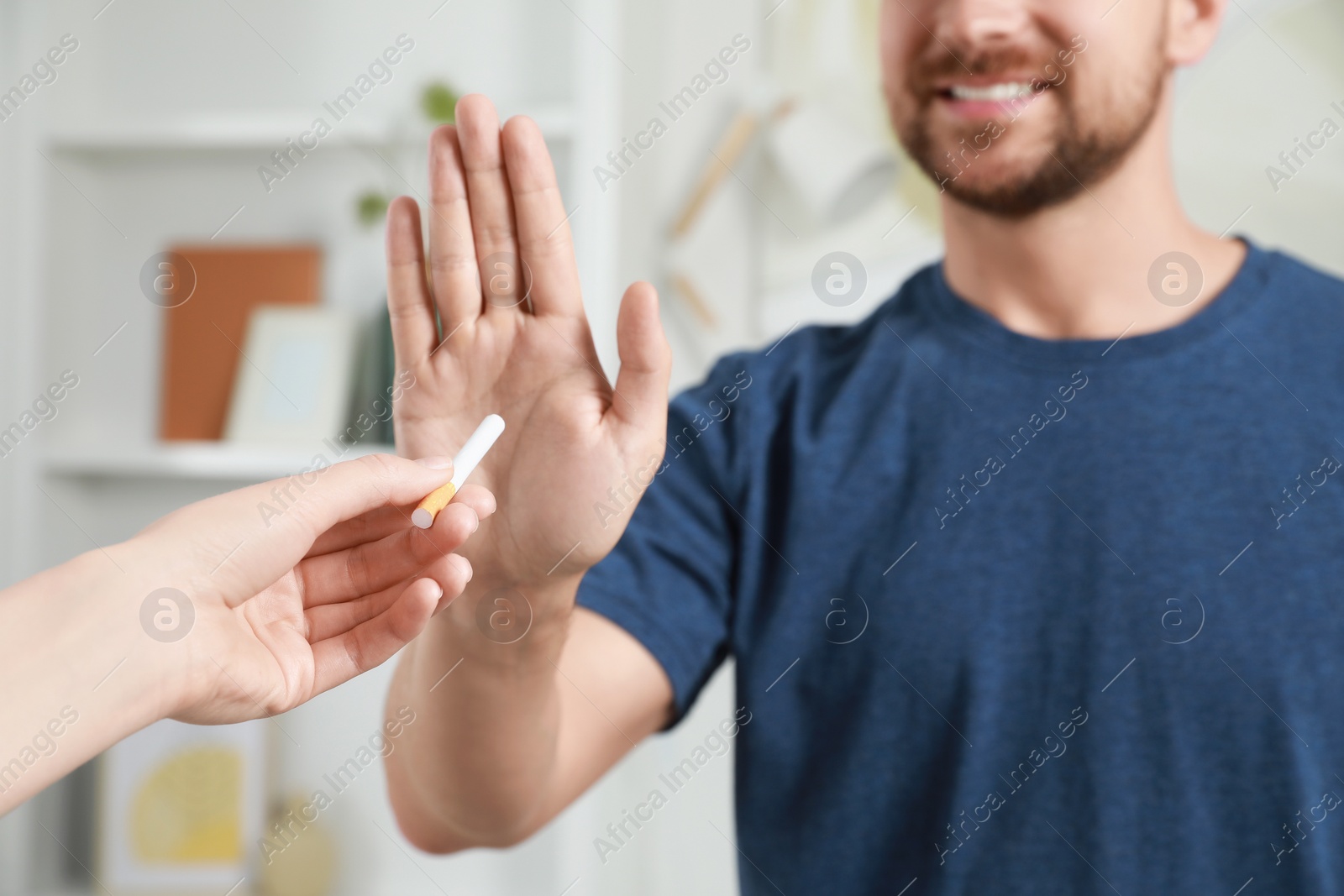 Photo of Man refusing cigarette indoors, closeup. Quitting smoking concept